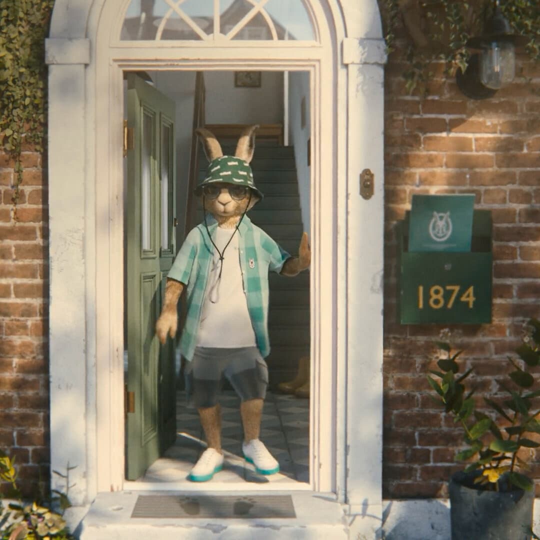 Вајлант Хер стои на влезната врата, носејќи шапка за сонце.