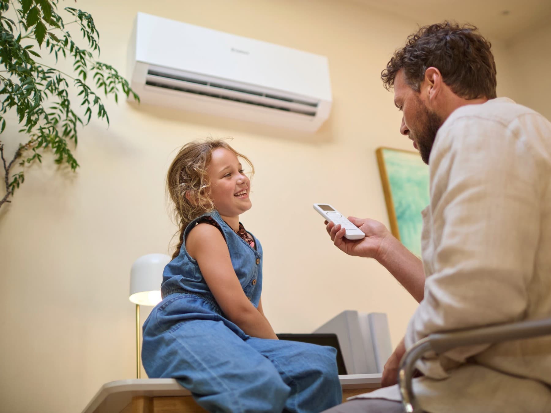 Татко и дете седат под клима уред