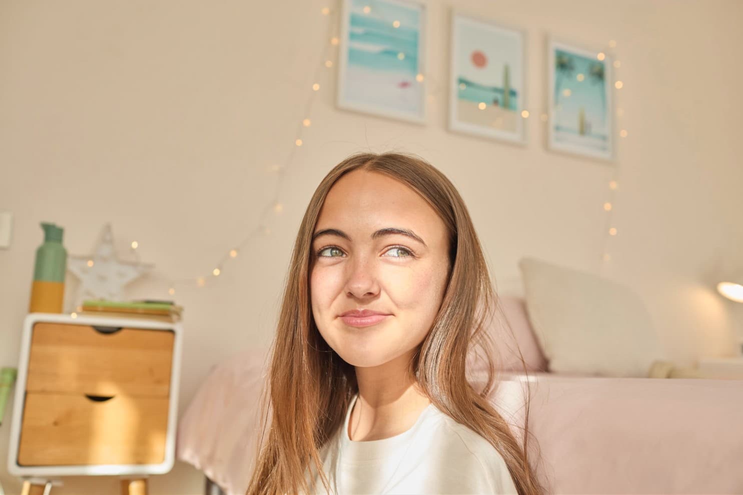 Девојка седи во соба и гледа низ прозорецот