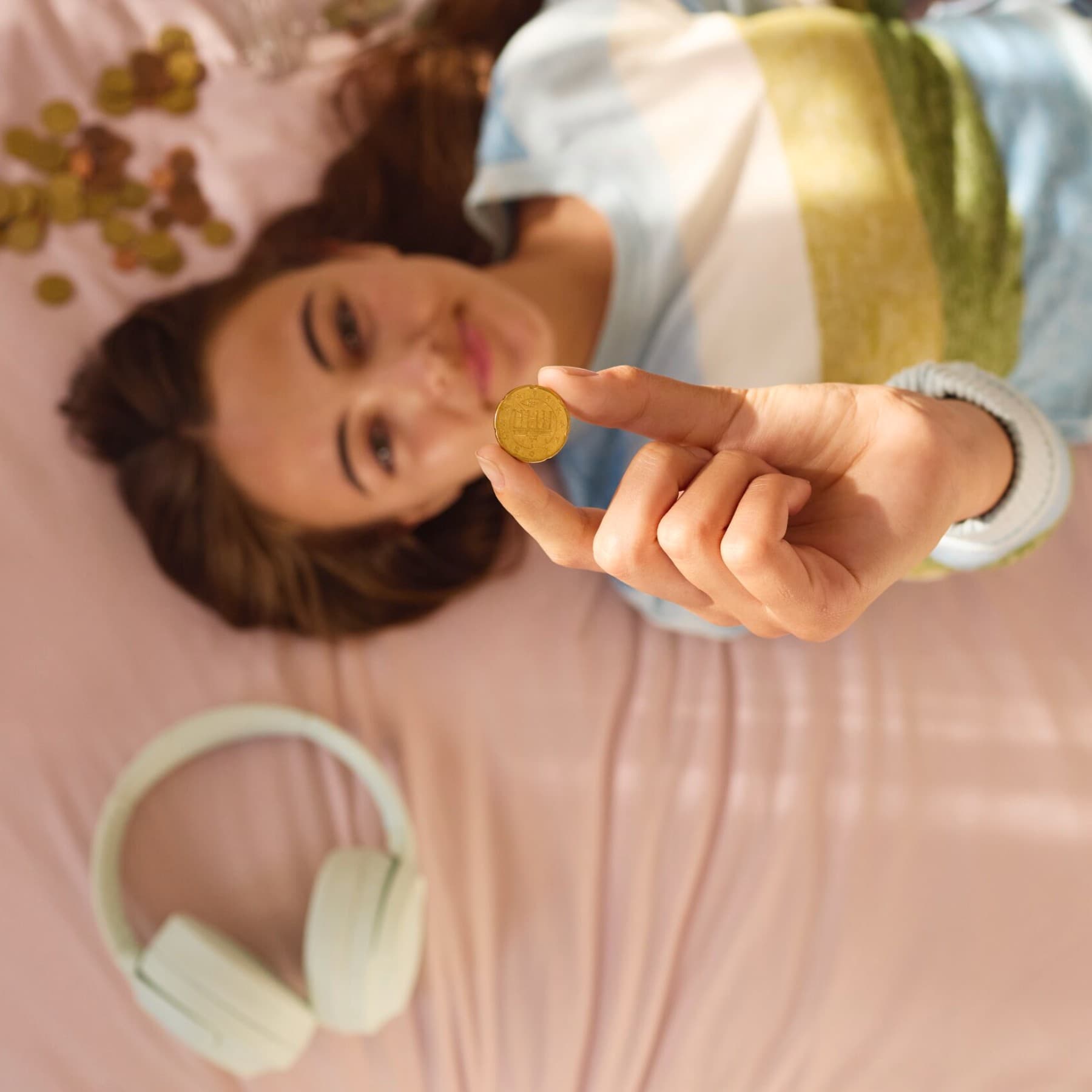 Жена лежи на кревет држејќи паричка