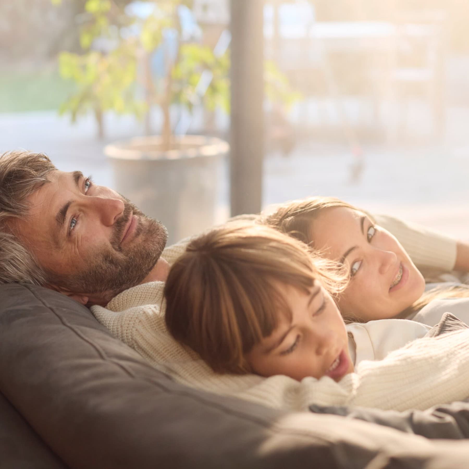 Татко и две деца се релаксираат на софа