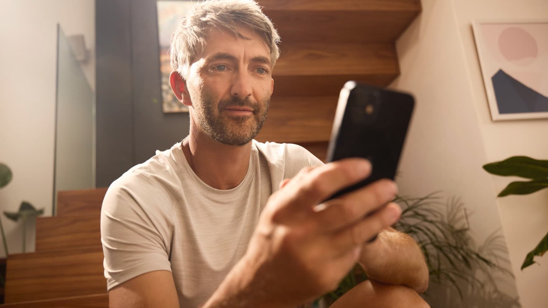 Човек го контролира својот систем за греење преку апликација