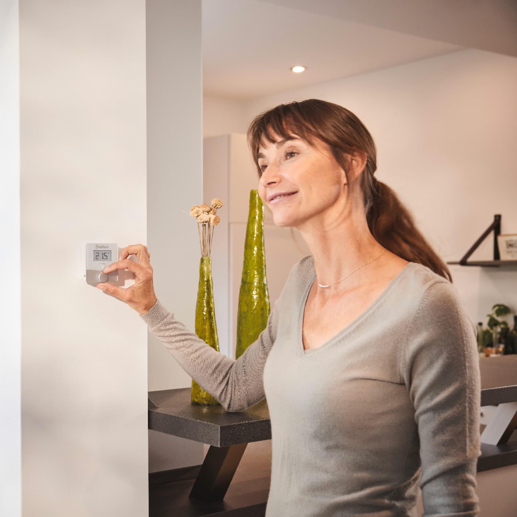 Жена врти термостат на ѕидот