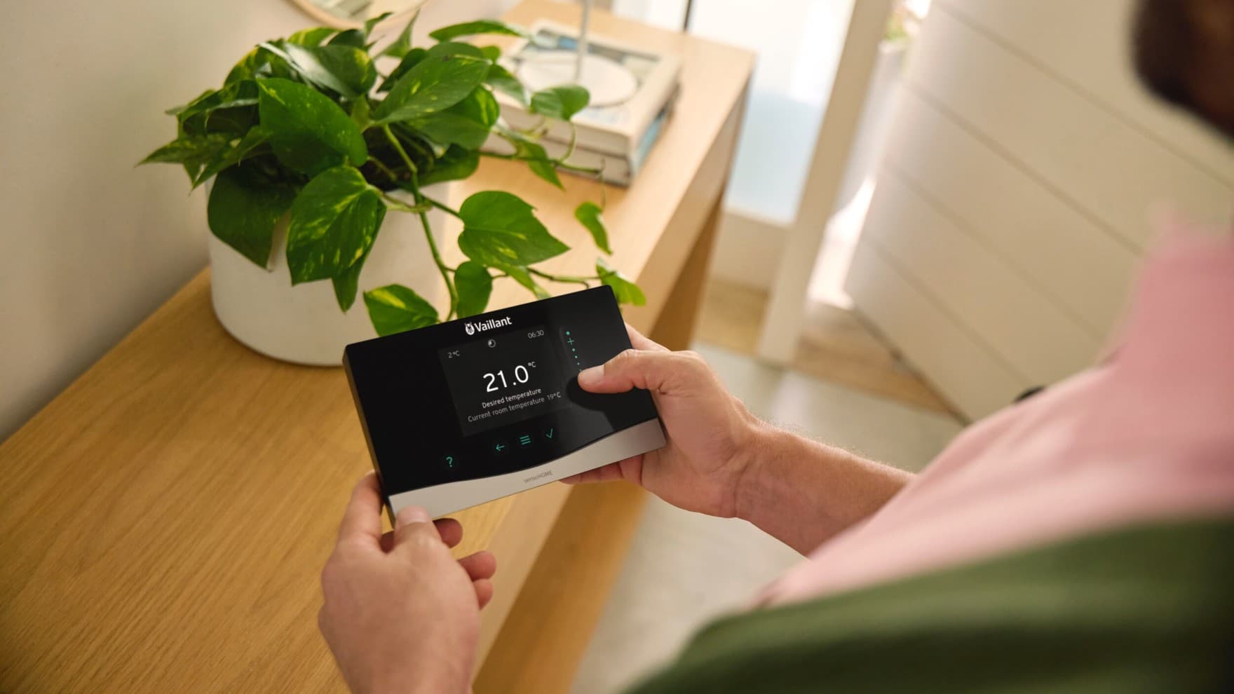 Човек држи контролна единица на Vaillant во раката