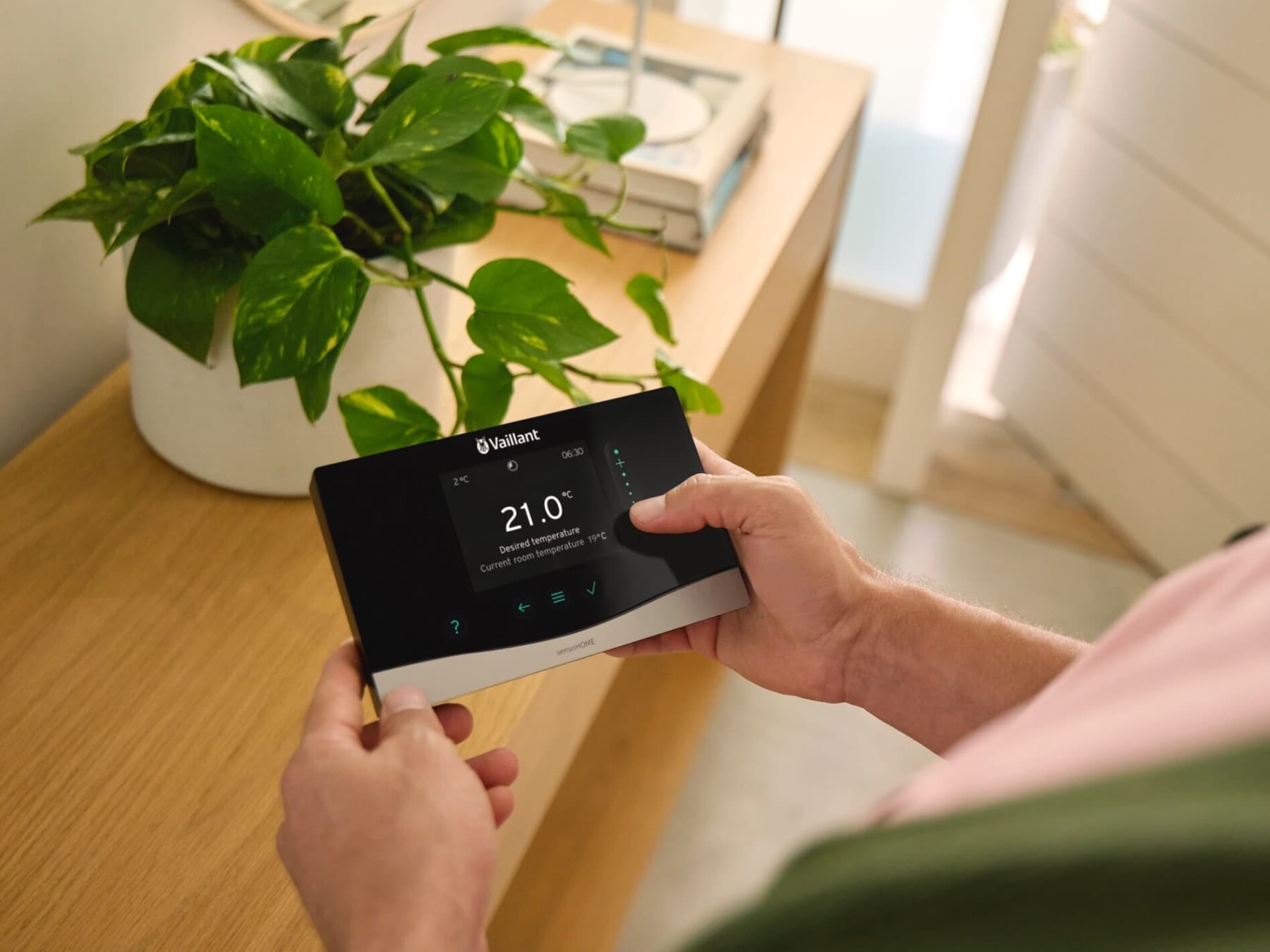 Човек го држи контролниот систем sensoCOMFORT во раката