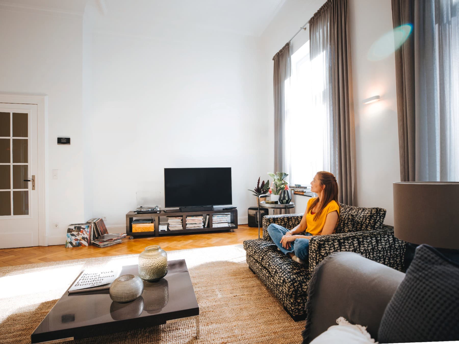 Жена седи на својата софа, уживајќи во мирот и тишината на совршена температура