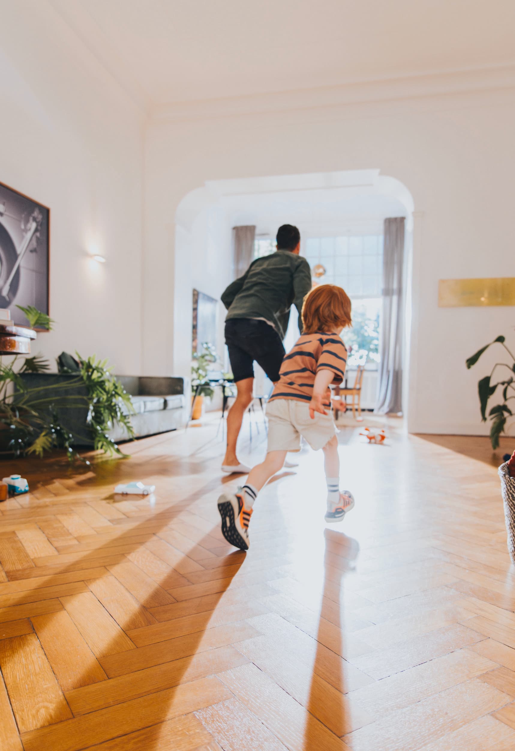 Човек си игра со своето дете во дневната соба.