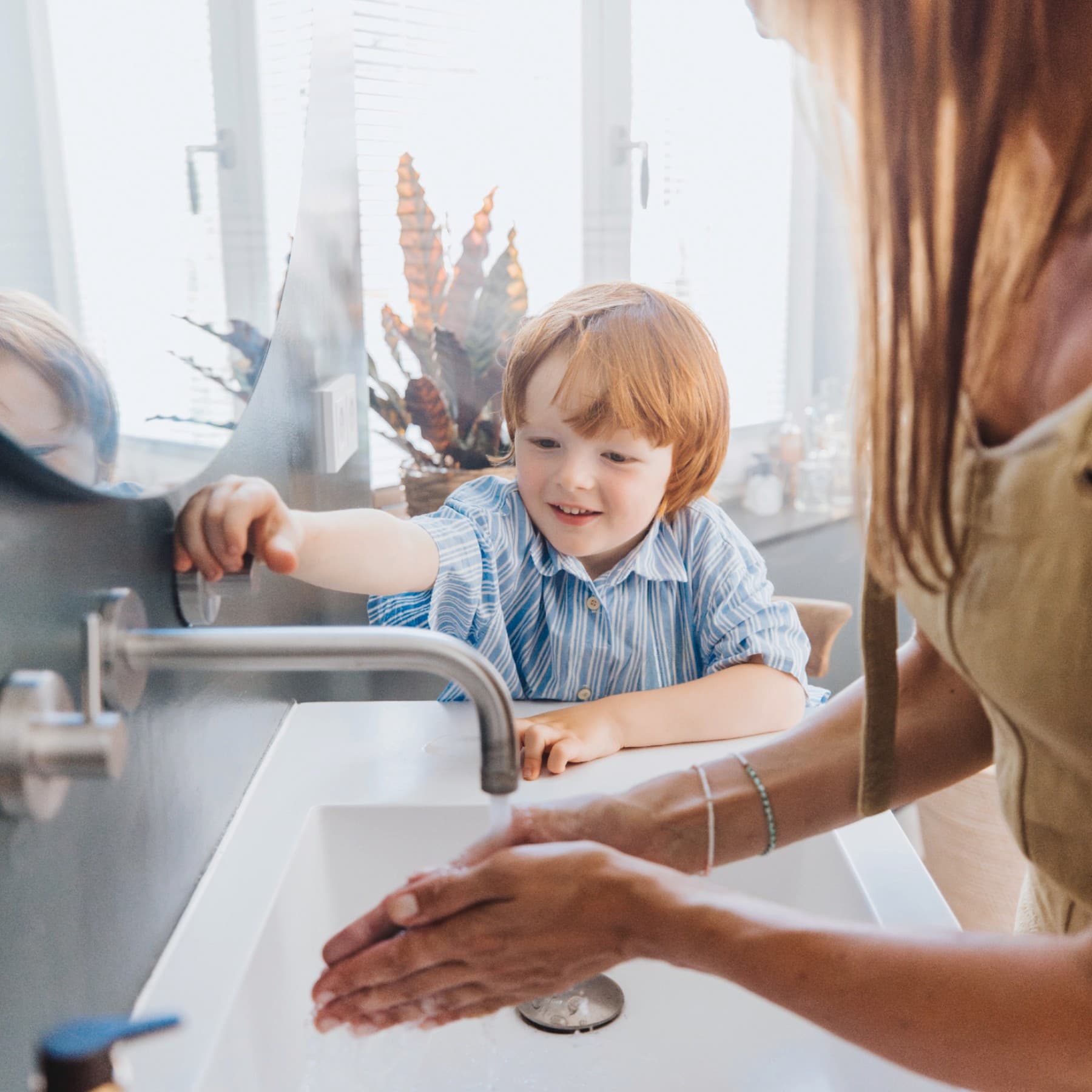 Момче и неговата мајка мијат раце