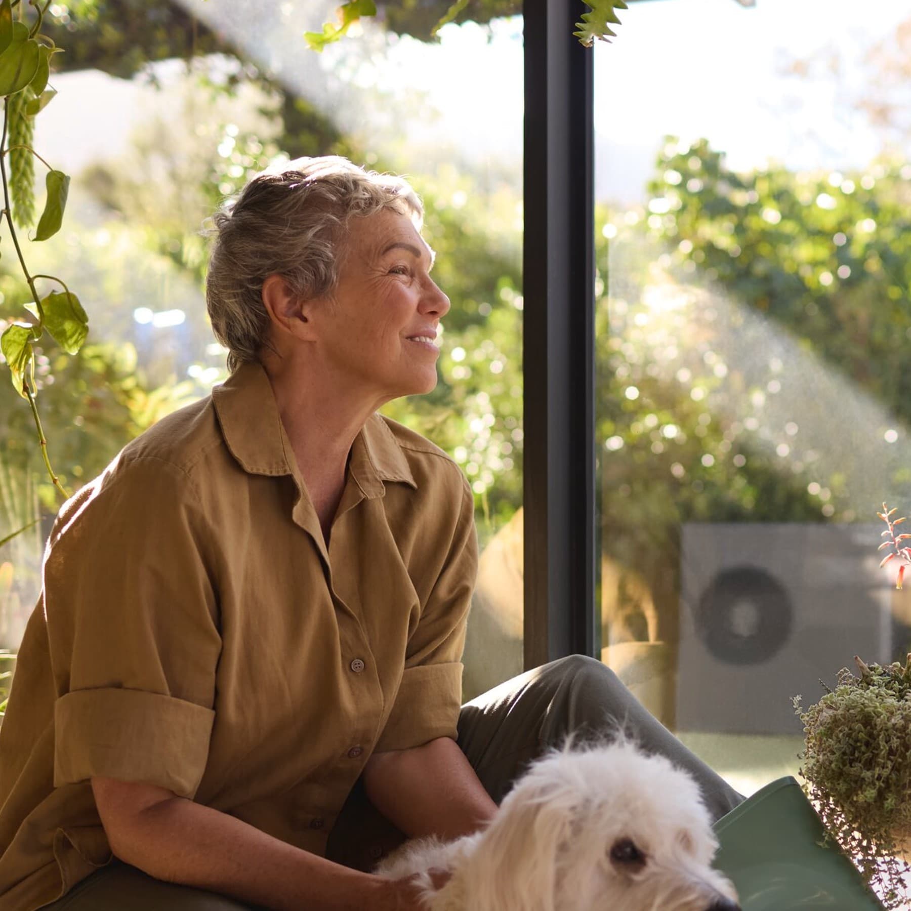 Жена седи со своето куче на прозорецот