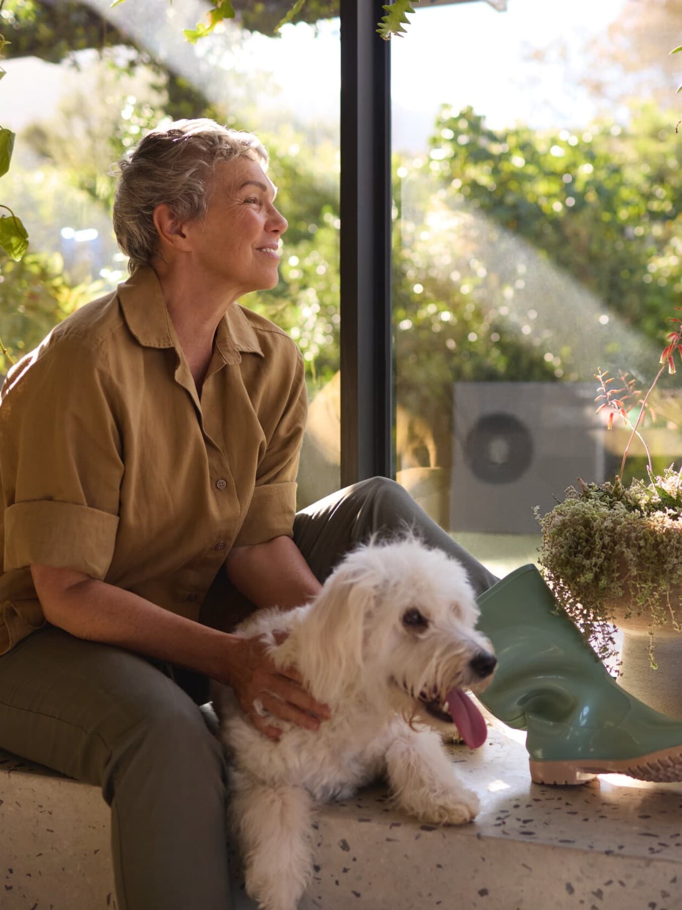 Топлинска пумпа Vaillant aroTHERM plus во градината и жена што седи на подот