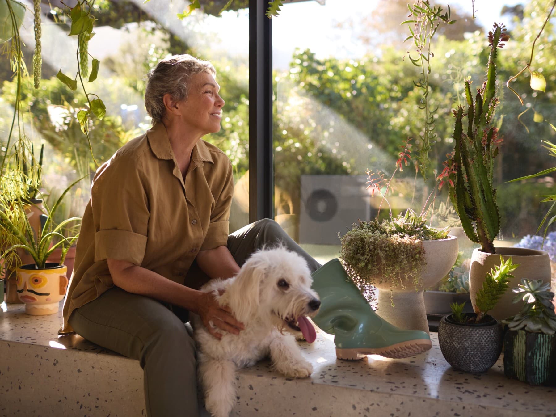 Жена седи со своето куче на прозорецот