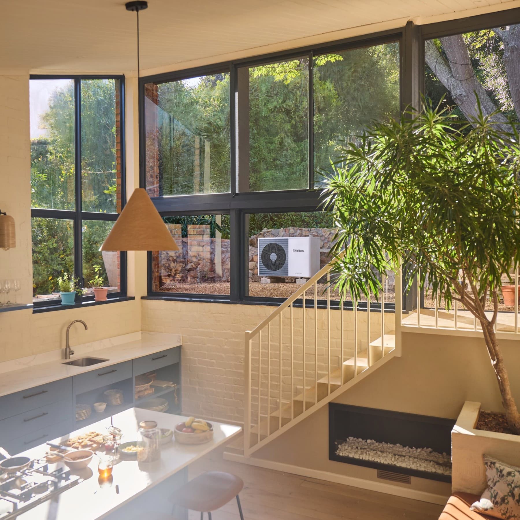 Топлинска пумпа Vaillant во градината видлива низ прозорецот