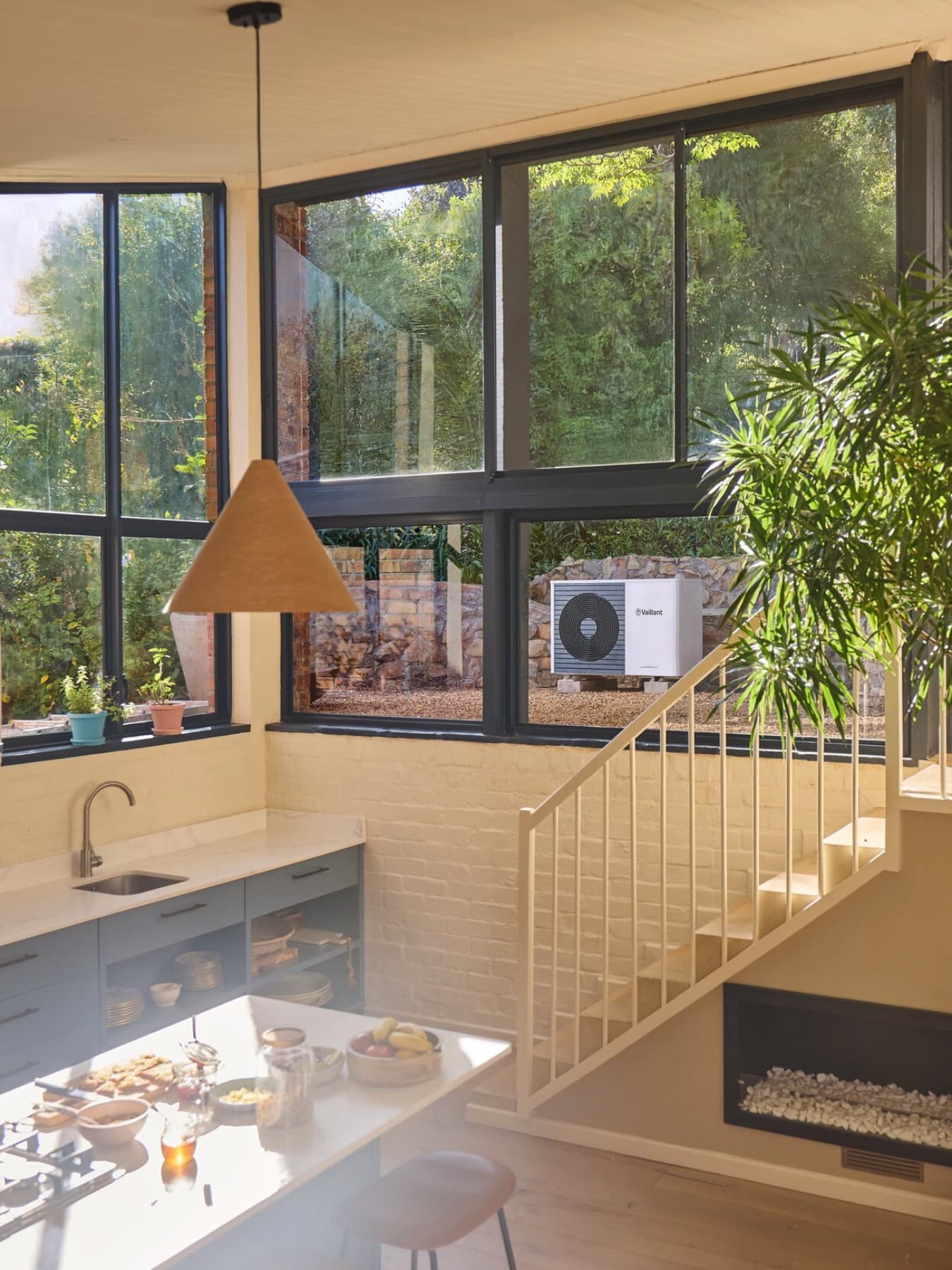 Топлинска пумпа Vaillant во градината видлива низ прозорецот