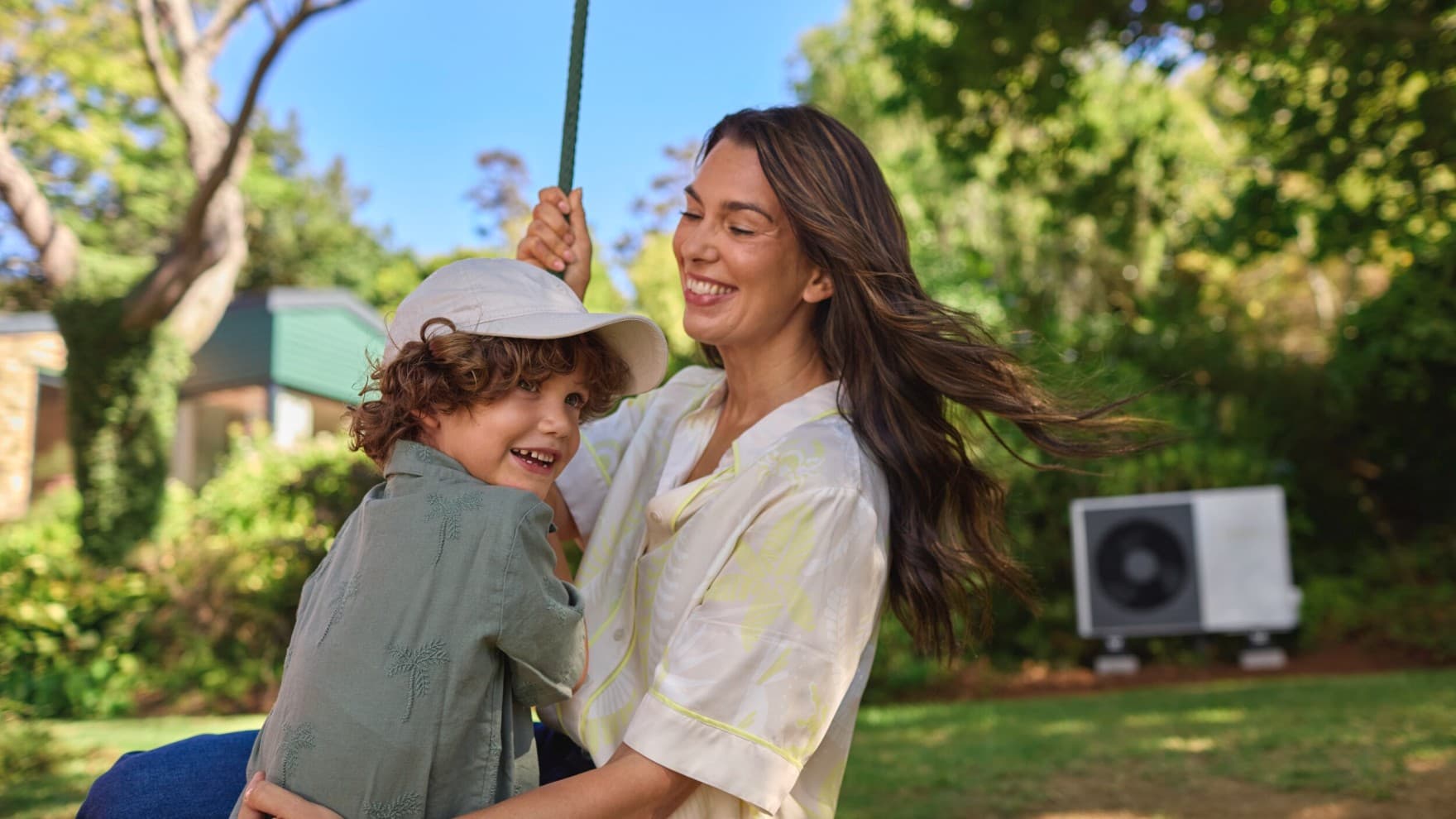 Мајка и син во градината пред нивната топлинска пумпа