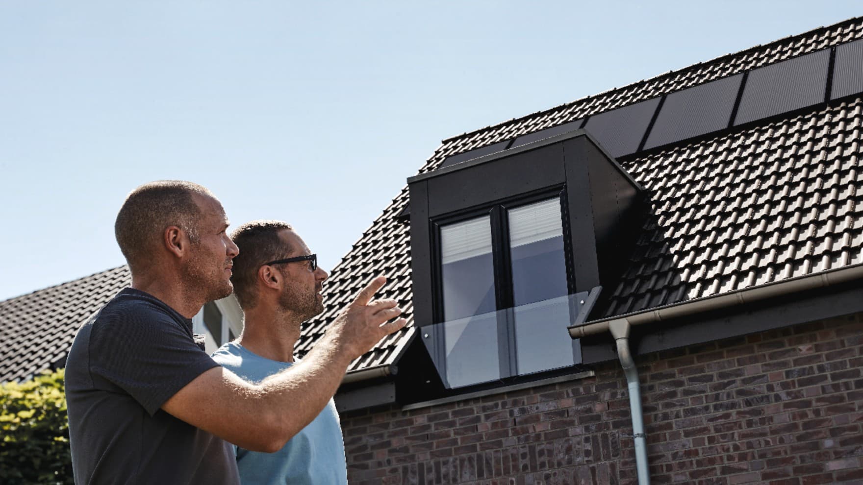 Мајсторите и сопственикот на куќата го проверуваат реновираниот покрив.