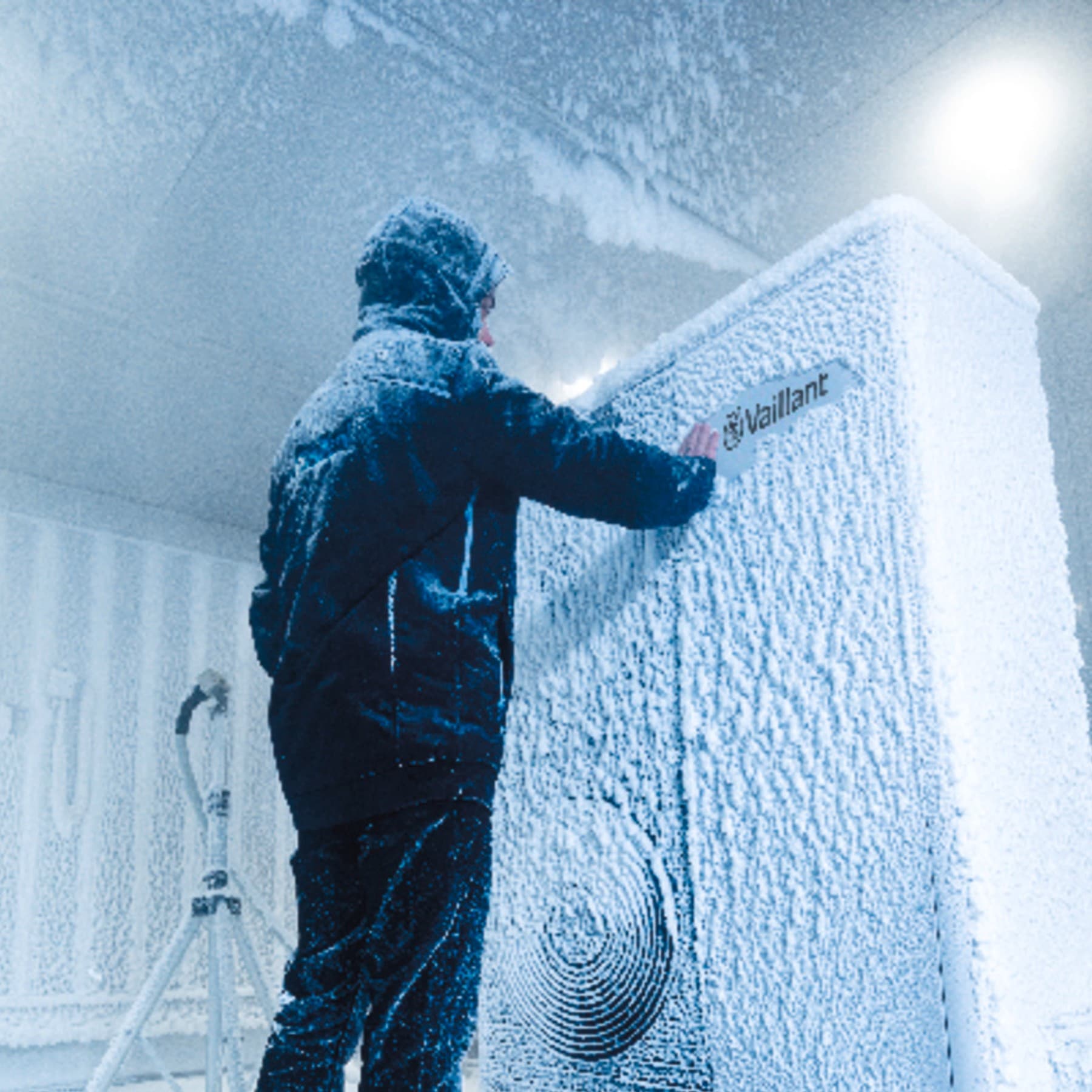 Човек во зимска јакна пред замрзнат апарат од Vaillant