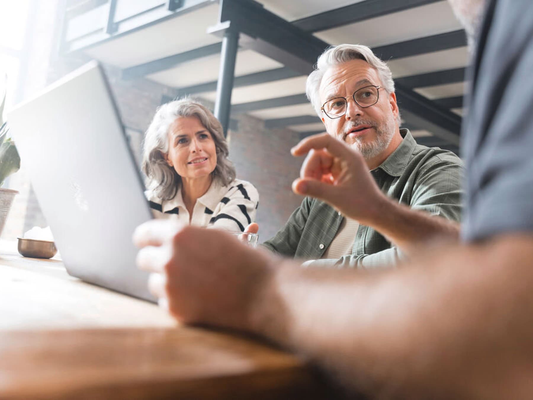 Ситуација со советување за бојлер дома - двојка седи на маса и разговара со инсталатер