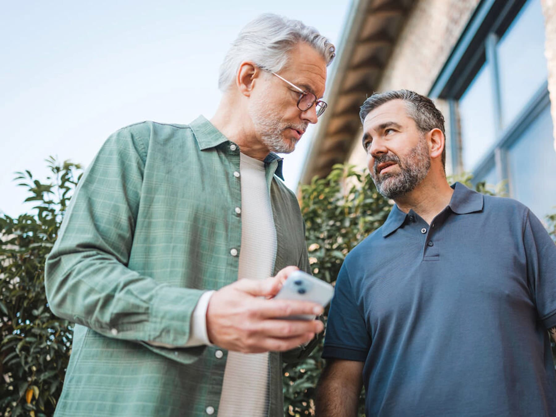 Инсталатер и краен корисник разговараат пред топлинската пумпа