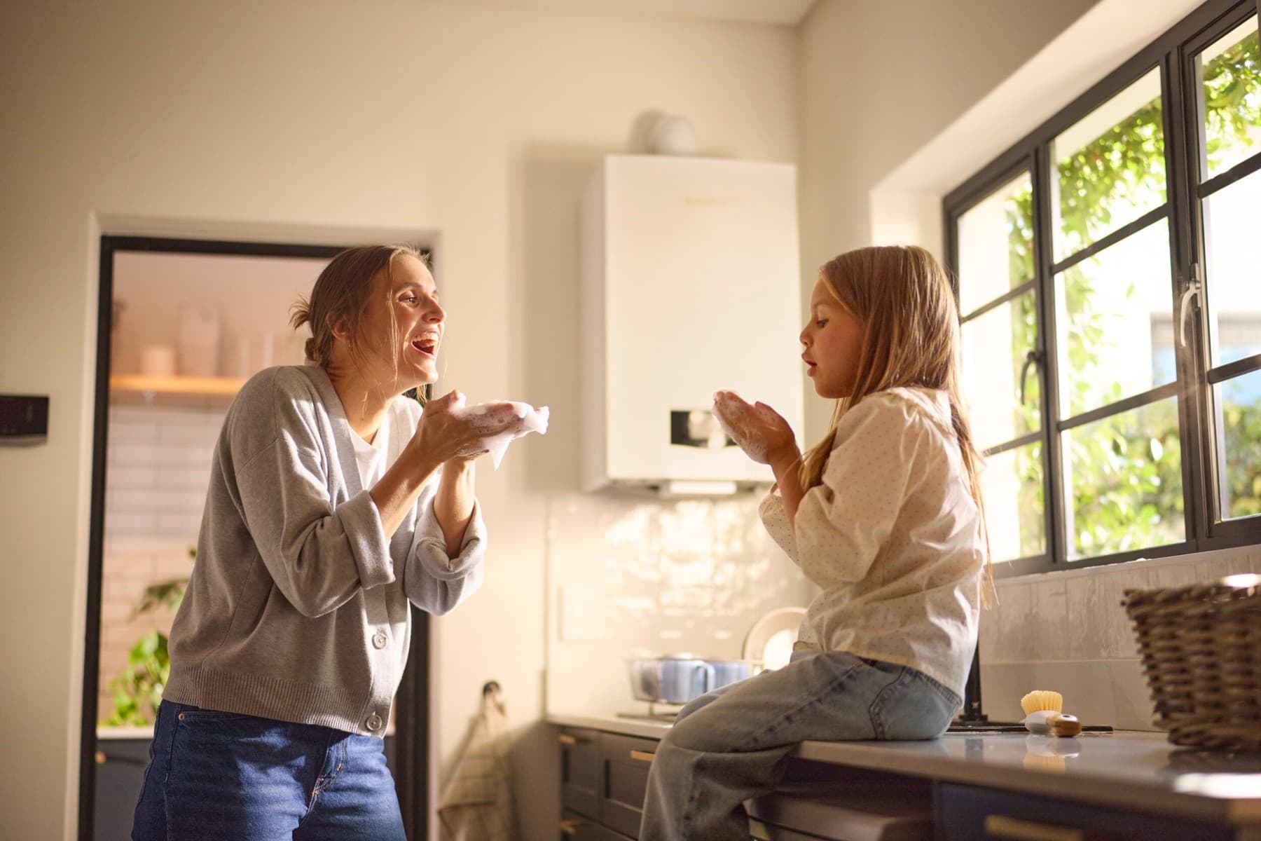 Мајка и ќерка си играат со меурчиња од сапуница