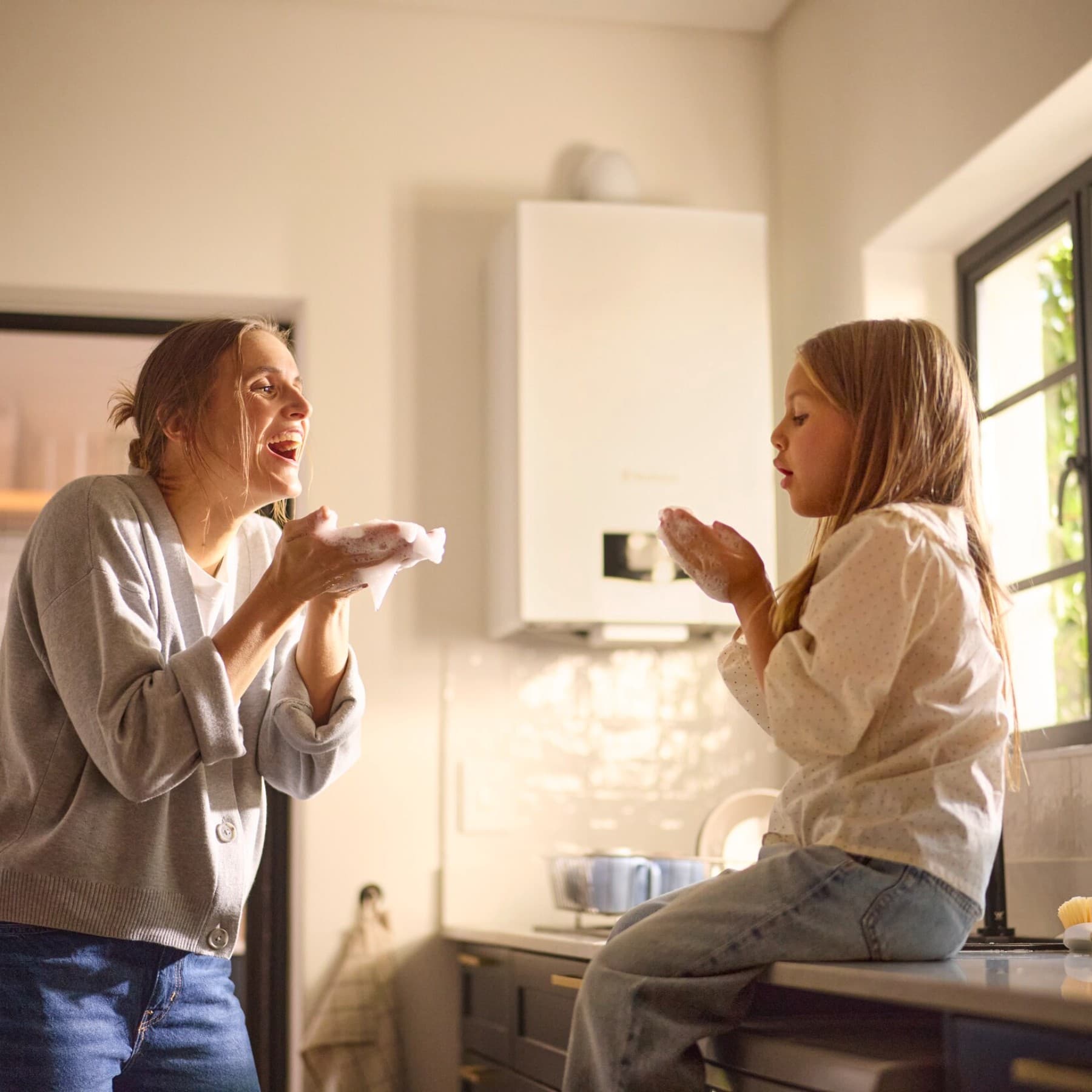 Мајка и ќерка си играат со меурчиња од сапуница